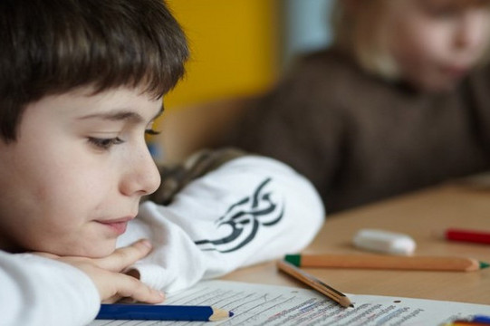 Im Klassenraum: Ein Kind schaut auf seine Schulaufgaben