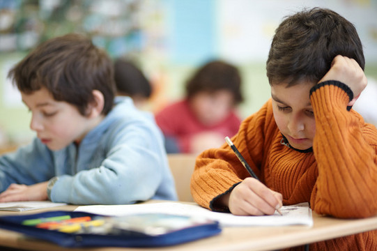 Im Klassenraum: Zwei Kinder bearbeiten ihre Schulaufgaben