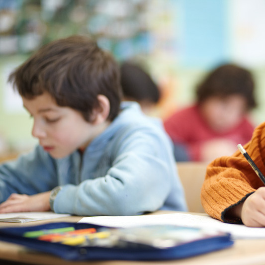Im Klassenraum: Zwei Kinder bearbeiten ihre Schulaufgaben
